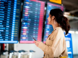 Woman looking at departure board at airport